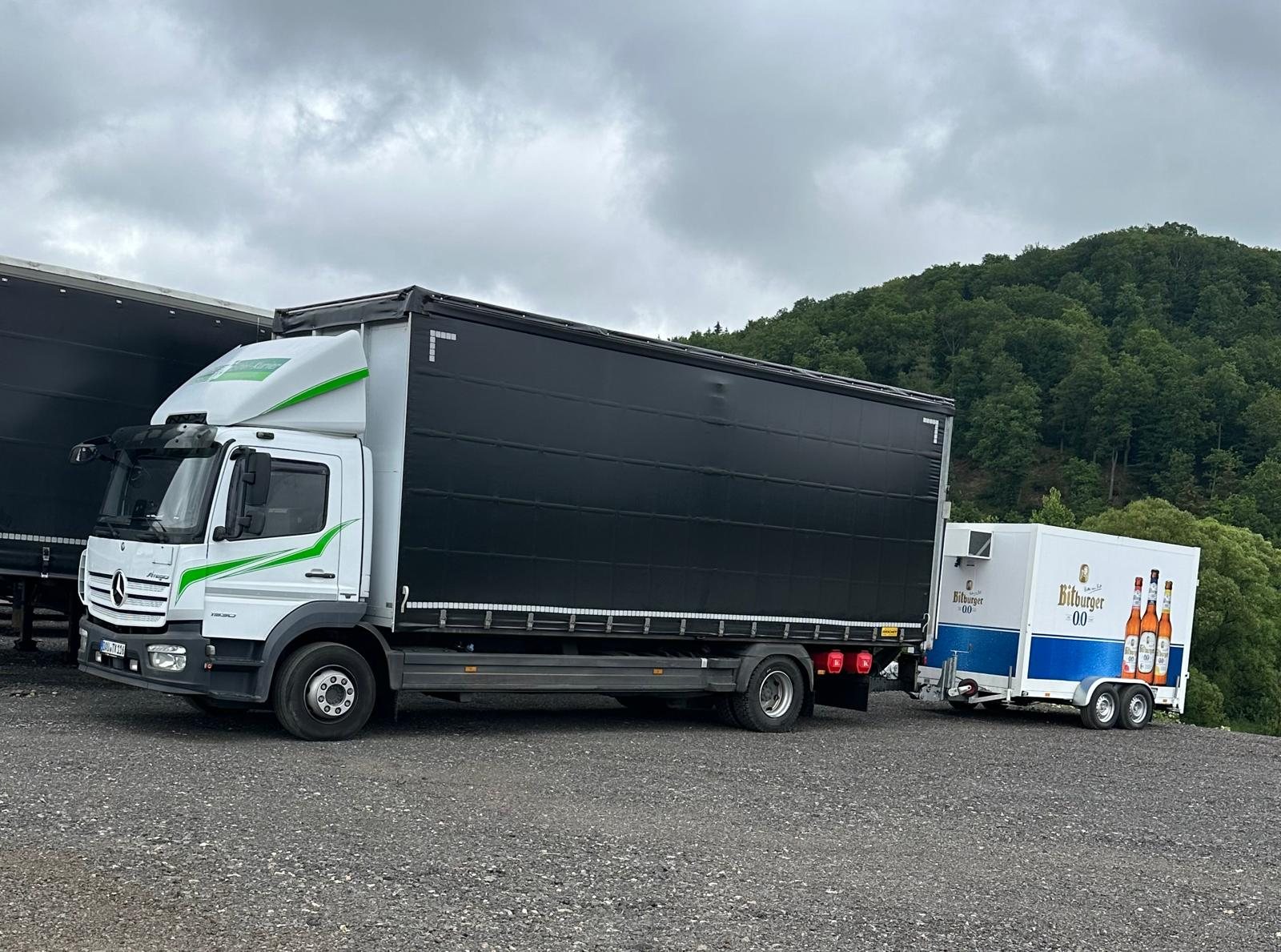 Eifel-Kurier Lastwagen mit Getränkeanhänger vor bewaldeter Eifellandschaft
