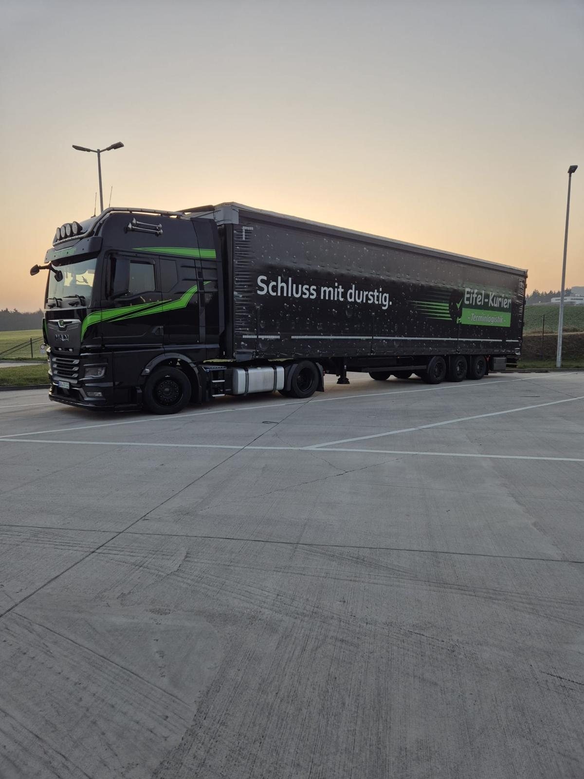 Eifel-Kurier Sattelzug mit dem Aufdruck „Schluss mit durstig“ im Morgenlicht