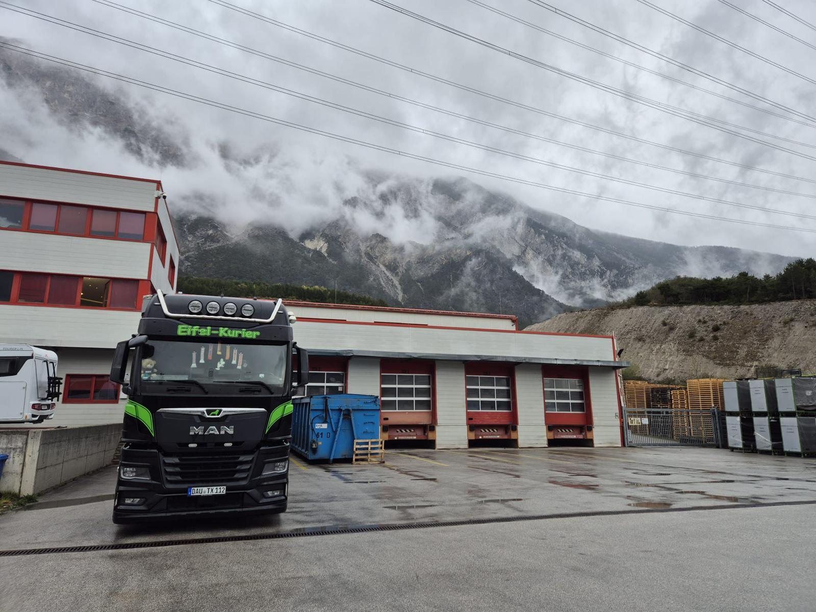 Eifel-Kurier Sattelzug an einem Logistikzentrum vor Bergkulisse